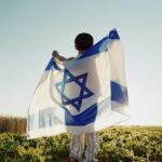 Happy Israeli Jewish Little Boy Jumping, Israel National Flag. Independence Day