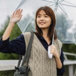 asian woman greeting a rainy day with umbrella