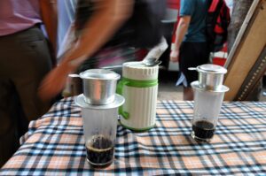 Brewing Vietnamese coffee with a single-cup filter. Phin traditional Vietnamese coffee maker