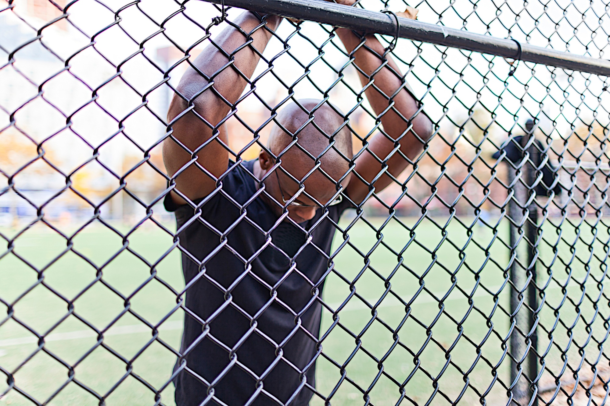 Man behind a chain link fence