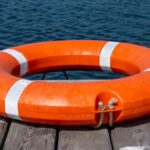 The lifebuoy is lying on a wooden pier. The concept of saving drowning